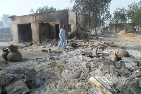 Image Text
 DEVASTATION A man surveys the damage in his village which was targeted by Boko Haram extremists on Saturday