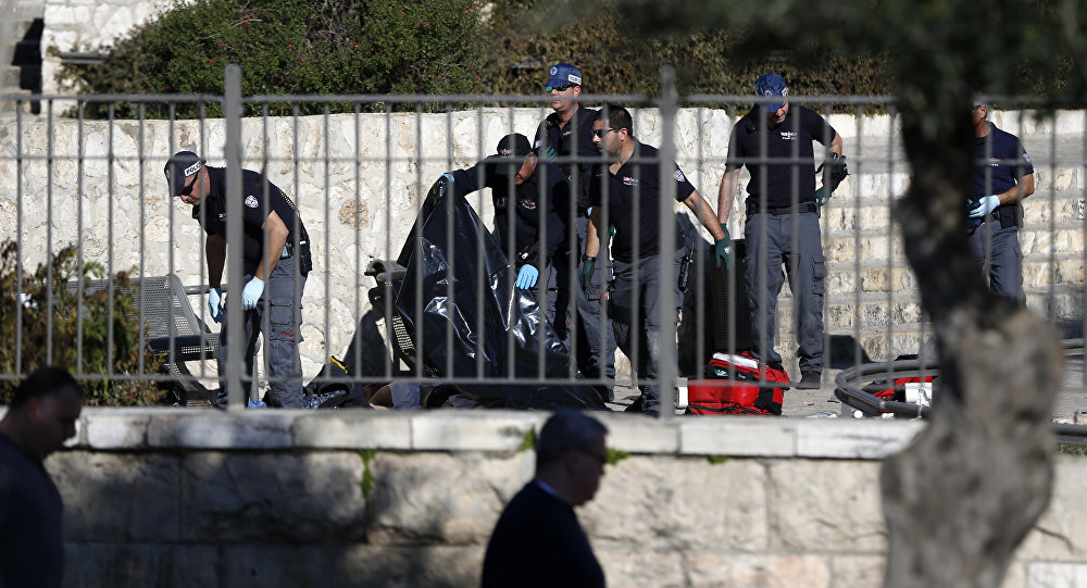 Israeli police officers investigate on the body of one of the reported Palestinian assailants killed during an attack at Damascus Gate a main entrance to Jerusalem's Old City