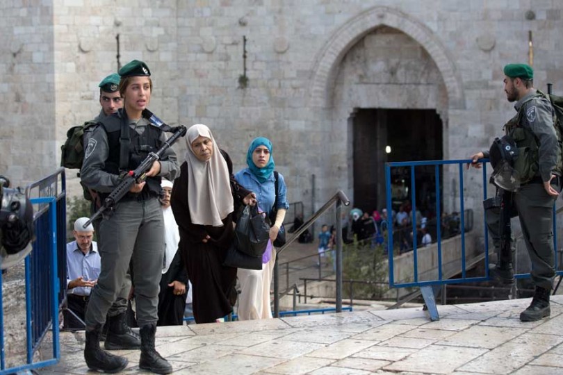 Palestinian women walk past Israeli border police at the Damascus Gate at the entrance of the Old City in east Jerusalem