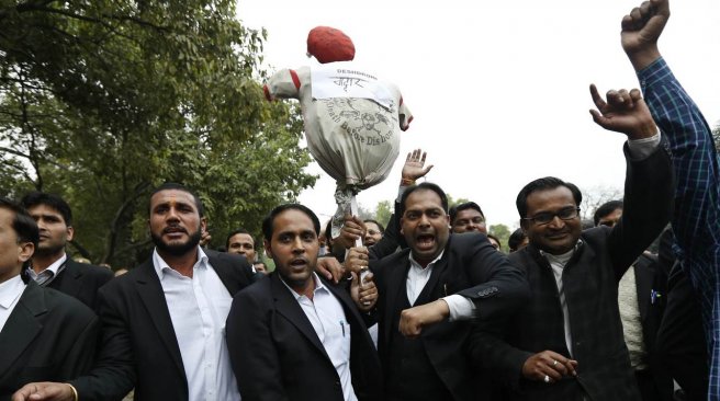 Indian lawyers shout slogans and carry an effigy as they take part in a demonstration in New Delhi