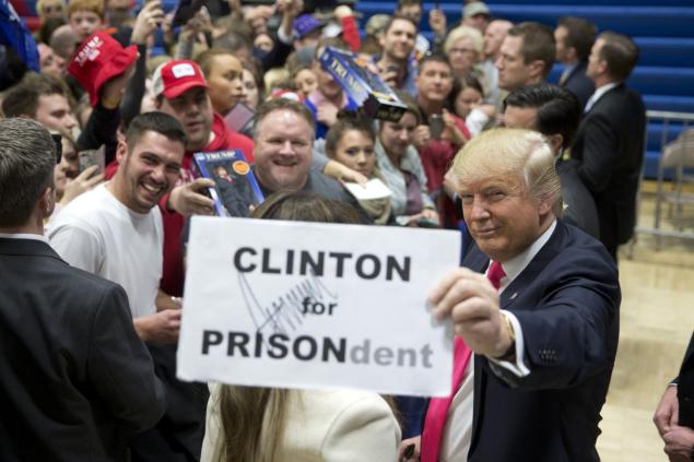 Donald Trump pauses with an autographed sign as he greets supporters at a rally in Council Bluffs Iowa on Sunday