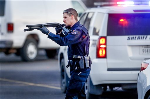 Police go through the parking lot of Excel Industries in Hesston Kan. Thursday Feb. 25 2016 where a gunman killed an undetermined number of people and injured many more