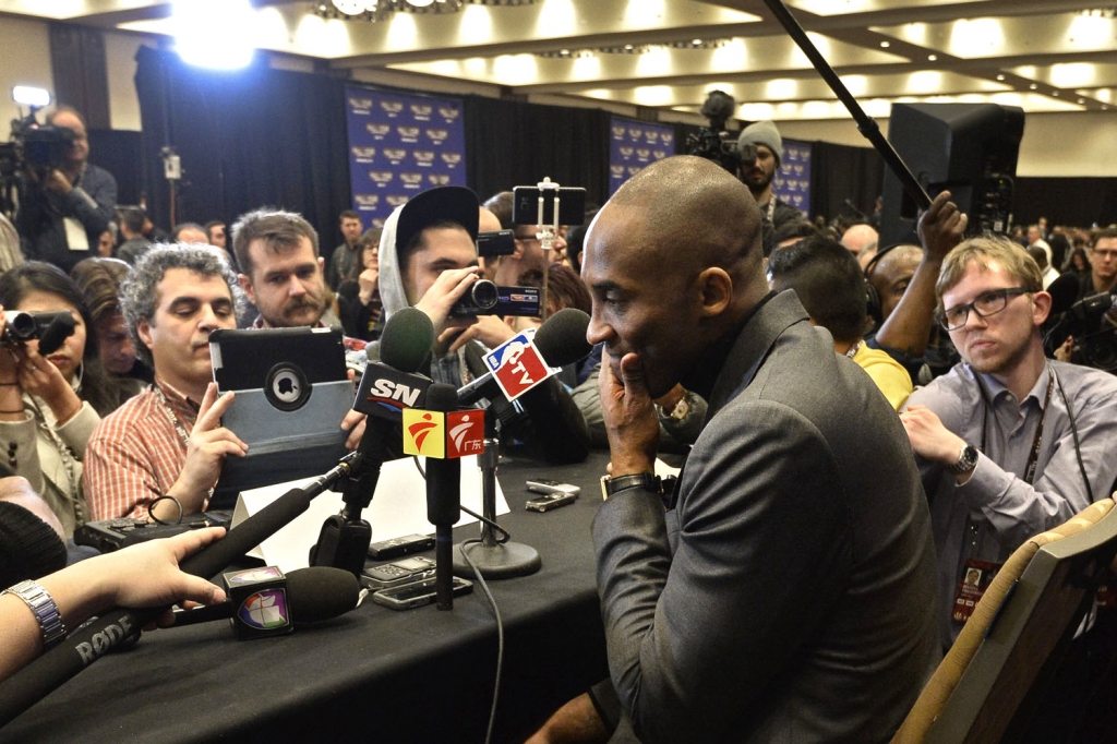 Kobe Bryant talks to a throng of reporters