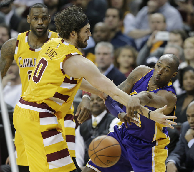 Los Angeles Lakers Kobe Bryant right passes around Cleveland Cavaliers Kevin Love in the first half of an NBA basketball game as Le Bron James watches Wednesday Feb. 10 2016 in Cleveland