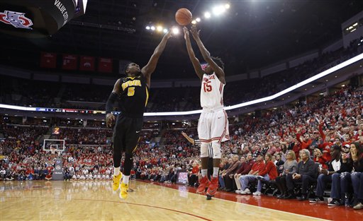 Ohio State's Kam Williams right makes a three-point goal over Iowa's Anthony Clemmons during the second half of an NCAA college basketball game Sunday Feb. 28 2016 in Columbus Ohio. Ohio State beat Iowa 68-64