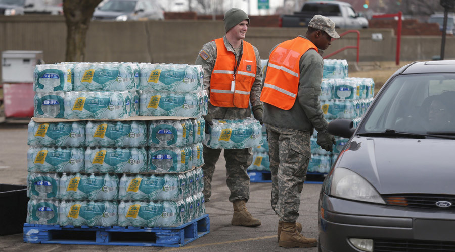 Michigan National Guardsmen distribute bottled water to Flint residents at a fire station in Flint Michigan