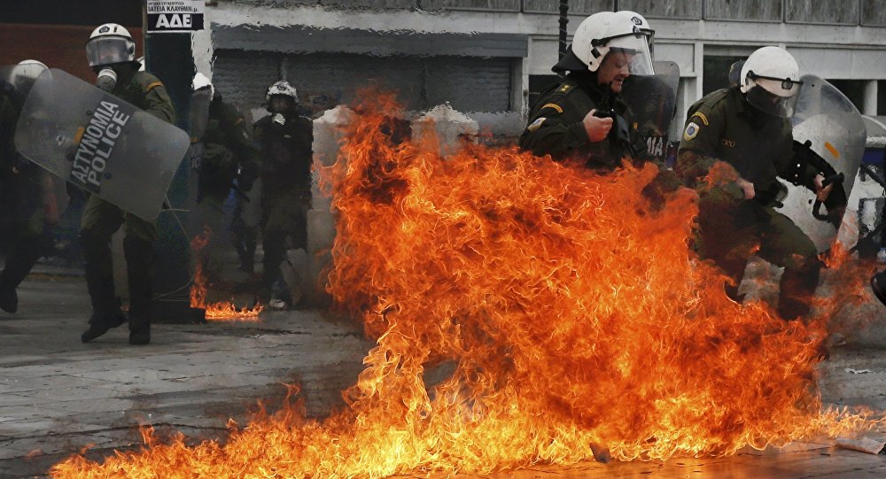 Riot police react to petrol bombs thrown by masked youths in Syntagma Square during a 24-hour general strike against planned pension reforms in Athens Greece