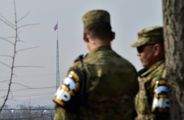 US soldiers stand guard at Taesungdong Elementary School as a North Korean flag fluttering over the propaganda village of Gijeongdong seen from South Korea