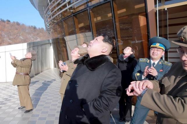 North Korean leader Kim Jong Un watches a long range rocket launch into the air in North Korea in this