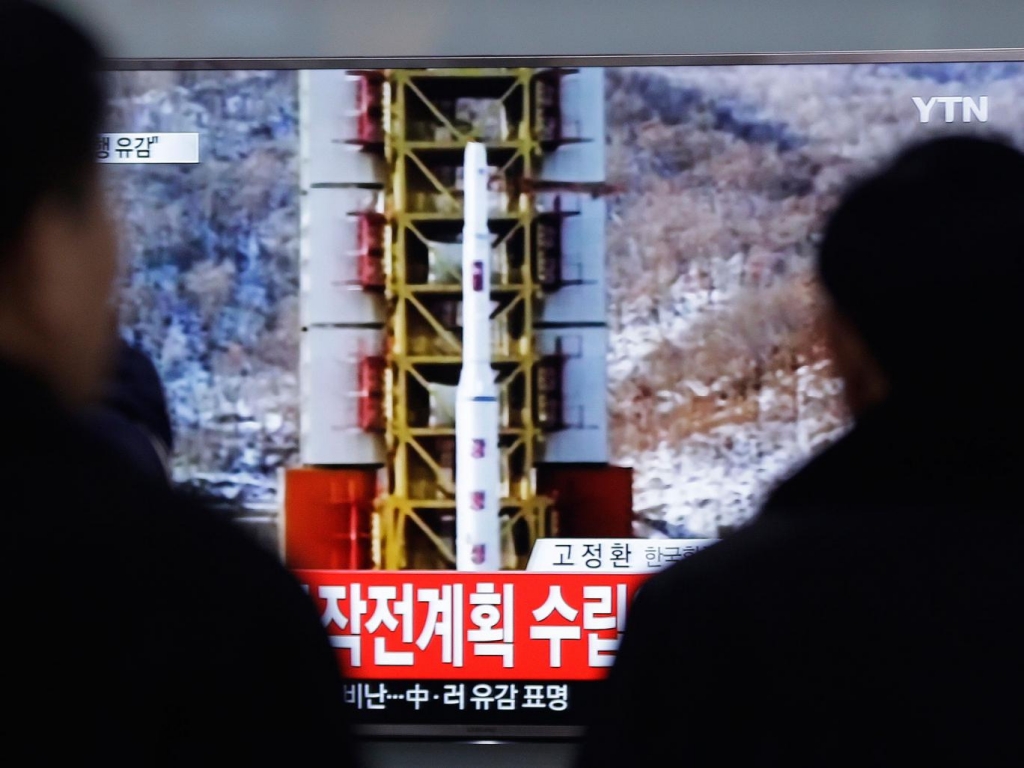 People watch a TV news reporting a rocket launch in North Korea at Seoul Railway Station in Seoul