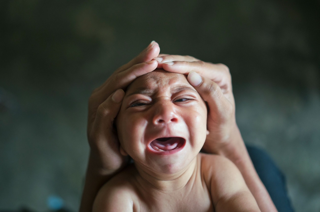 Elielson tries to calm down his baby brother Jose Wesley in Bonito Pernambuco state Brazil. Jose Wesley was born with microcephaly and he screams uncontrollably for long stretches get