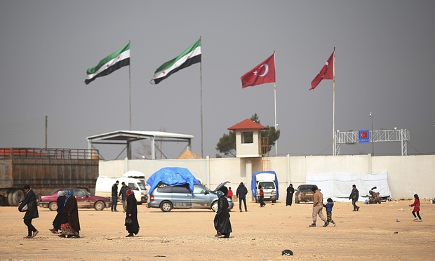 People walk on the Syrian side of the Bab al Salam border crossing with Turkey