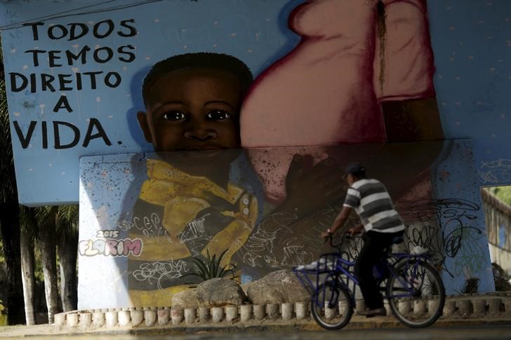 A man walks in front of a graffiti of pregnancy on an overpass in Recife Brazil