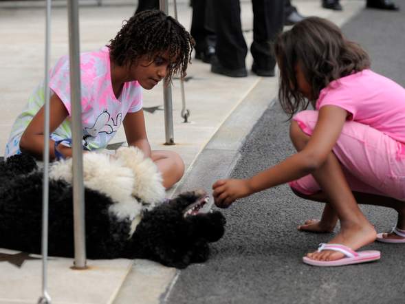 U.S. President Obama's daughters Malia and Sasha wait for his return to Washington