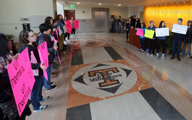 Protestors stand outside Dave Hart's press conference