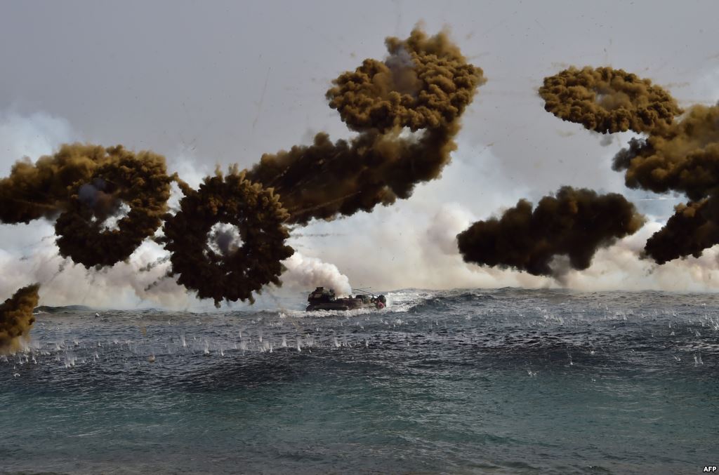 FILE- South Korean Marine amphibious assault vehicles fire smoke shells to land on the seashore during a joint landing operation by US and South Korean Marines in the southeastern port of Pohang