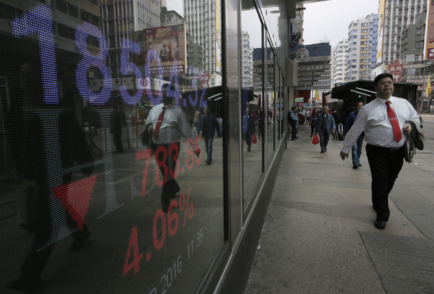 A man walk past a bank electronic board showing the Hong Kong share index at Hong Kong Stock Exchange Thursday Feb. 11 2015. Hong Kong's stocks are set for