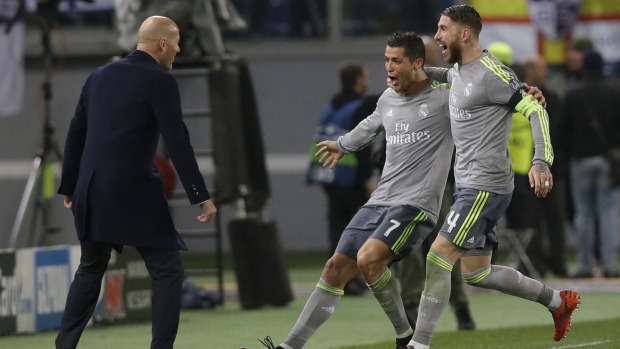 Real Madrid's Cristiano Ronaldo celebrates with coach Zinedine Zidane, and Sergio Ramos after scoring the opening goal