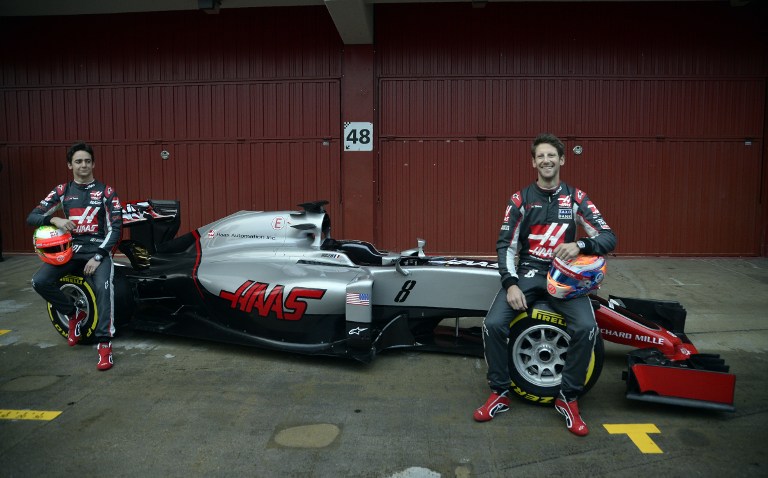 HAAS F1 team Mexican driver Esteban Gutierrez and Swiss Romain Grosjean smile as they pose on their new VF-16 car during the official presentation at the Circuit de Catalunya in Montmelo on the outskirts of Barcelona on the first test day of the Fo