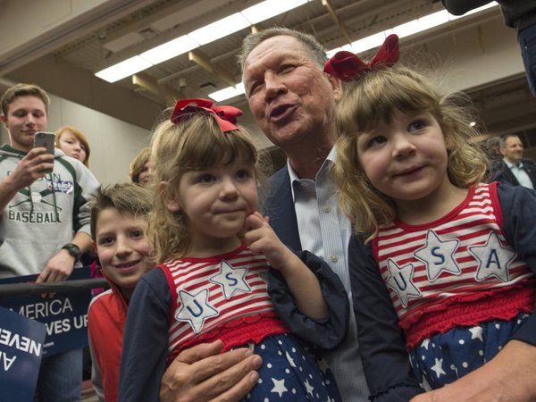 Republican presidential candidate Ohio Gov. John Kasich poses with three and a half year old twins Emerie and Ellie Farnsworth of Springfield Va. after speaking at a Town Hall at George Mason University in Fairfax Va. Monday Feb. 22 2016. (AP