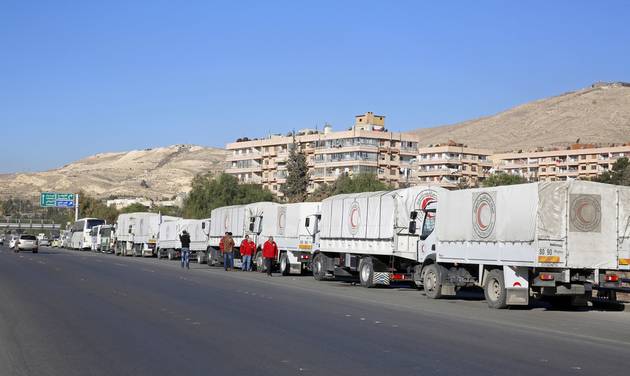 A convoy of humanitarian aid waits in front of the United Nations Relief and Works Agency offices before making their way into the government besieged rebel-held towns of Madaya al Zabadani and al Moadhamiya in the Damascus countryside as part