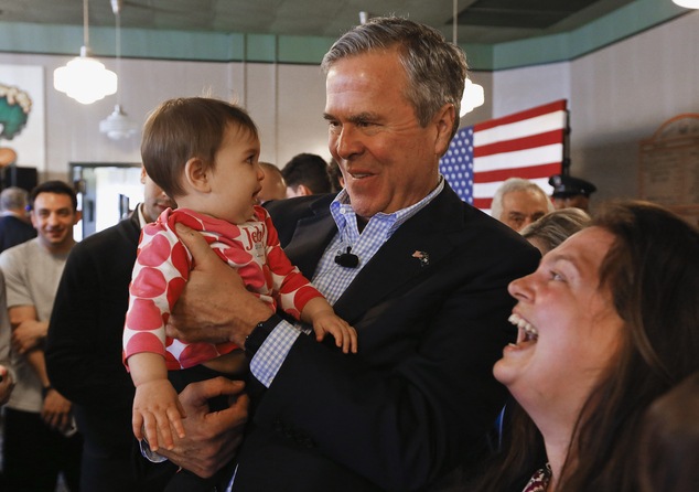 Republican presidential candidate former Florida Gov. Jeb Bush holds nine-moth-old Shanaya Amber as her mother Brandy looks on during a campaign stop at Wad