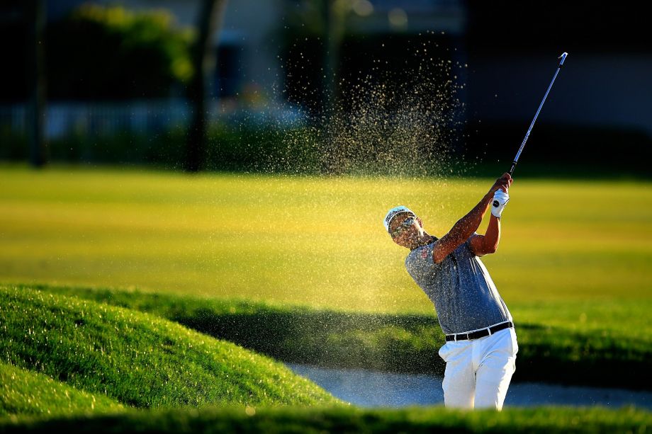 Adam Scott plays his second shot on the par-5 18th hole. He took a quadruple bogey on the 15th but managed to share the lead with Sergio Garcia