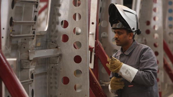 An Indian worker welds fuselage at a Bombardier factory in Germany