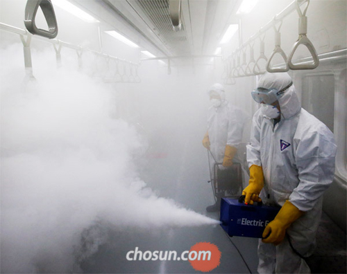 Staff sanitize a subway train in Seoul on Wednesday