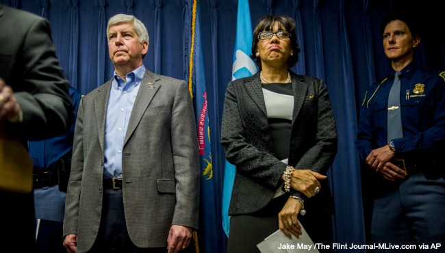 Gov. Rick Snyder left stands beside Flint Mayor Karen Weaver as they prepare to field questions from the media about the Flint water crisis during a press conference on Wednesday Jan. 27 2016 at City Hall in downtown Flint Mich