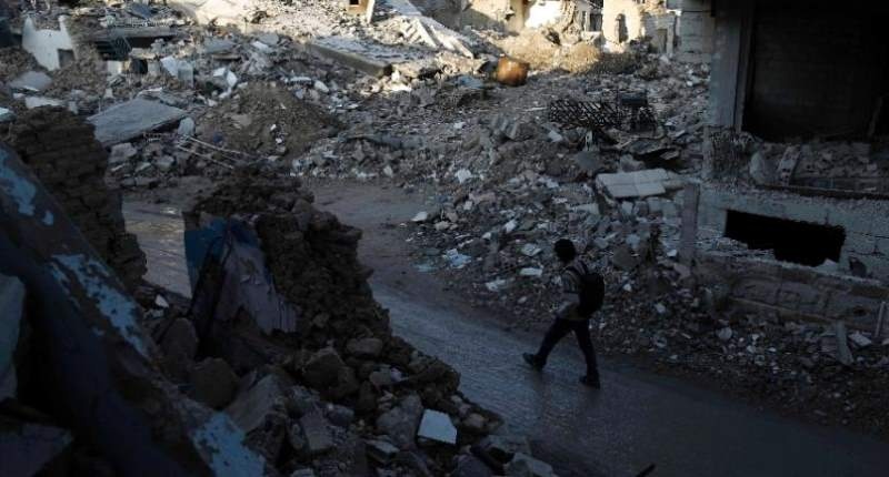 A Syrian man walks along a street damaged by shelling in the neighbourhood of Jobar on the eastern outskirts of the capital Damascus on Feb. 24 2016