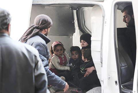 Syrian civil defence members evacuate a family following reported air strikes by regime forces on the Kafr Batna town in the rebel-held Eastern Ghouta area on the outskirts of the capital Damascus