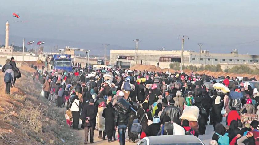 Syrians fleeing from the northern embattled city of Aleppo walk towards the frontier post of Bab al Salama bordering with Turkey yesterday