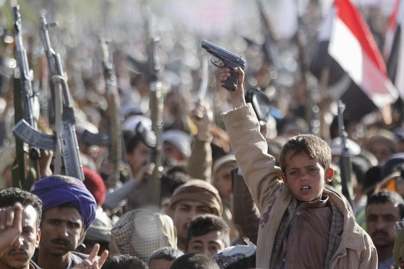 A boy shouts slogans as he raises a gun during a rally against U.S. support to Saudi-led air strikes in Yemen's capital Sanaa