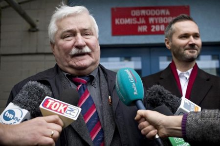 Former Poland's president Lech Walesa addresses media next to his son Jaroslaw outside a polling station in Gdansk Poland