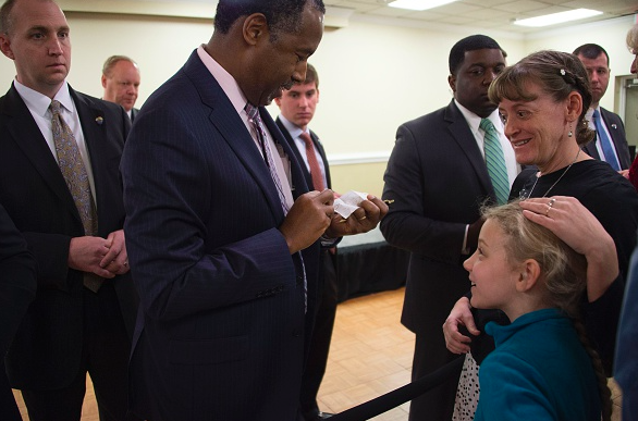 Republican presidential candidate Ben Carson open a drawing from a young girl as he talks with supporters after speaking at a veteran's roundtable in Columbia South Carolina