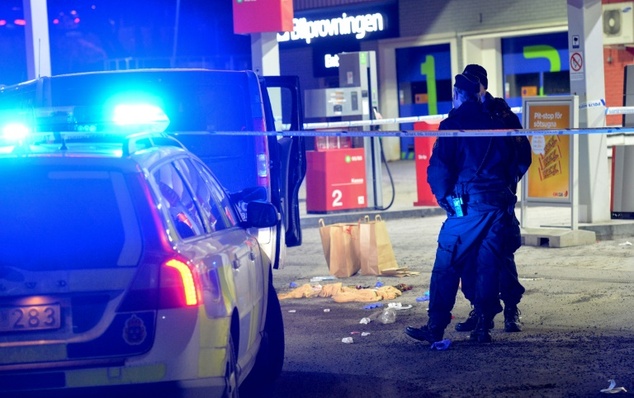 Police cordon off an area at a petrol station where a man was found severely injured after being shot on the sidelines of a pro Kurdish demonstration in Fitt