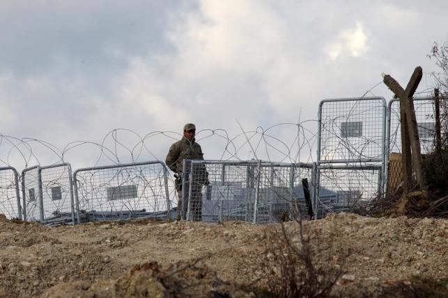 A Turkish soldier standing guard is seen from the Syrian town of Khirbet Al Joz at the Turkish Syrian border in Latakia countryside where internally displaced Syrian people are waiting to get permission to cross into Turkey