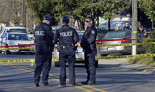 Officers investigate the scene of a shooting in Baton Rouge La. Saturday Feb. 13 2016. Police officers who were shot early Saturday during a confrontation with a suspect were responding to a call about someone damaging property