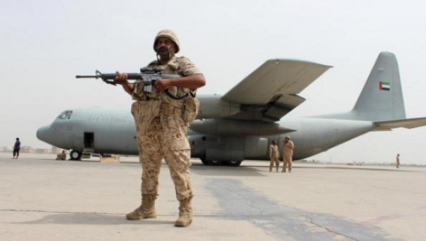 A soldier from the United Arab Emirates stands guard next to a UAE military plane at the airport of Yemen