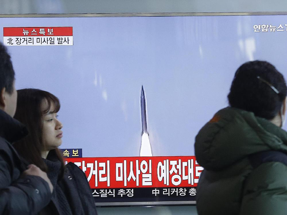 South Koreans watch a TV news program with a file footage about North Korea's rocket launch on Sunday. North Korea on Sunday defied international warnings and launched a long-range rocket that the United Nations and others call a cover for a banned