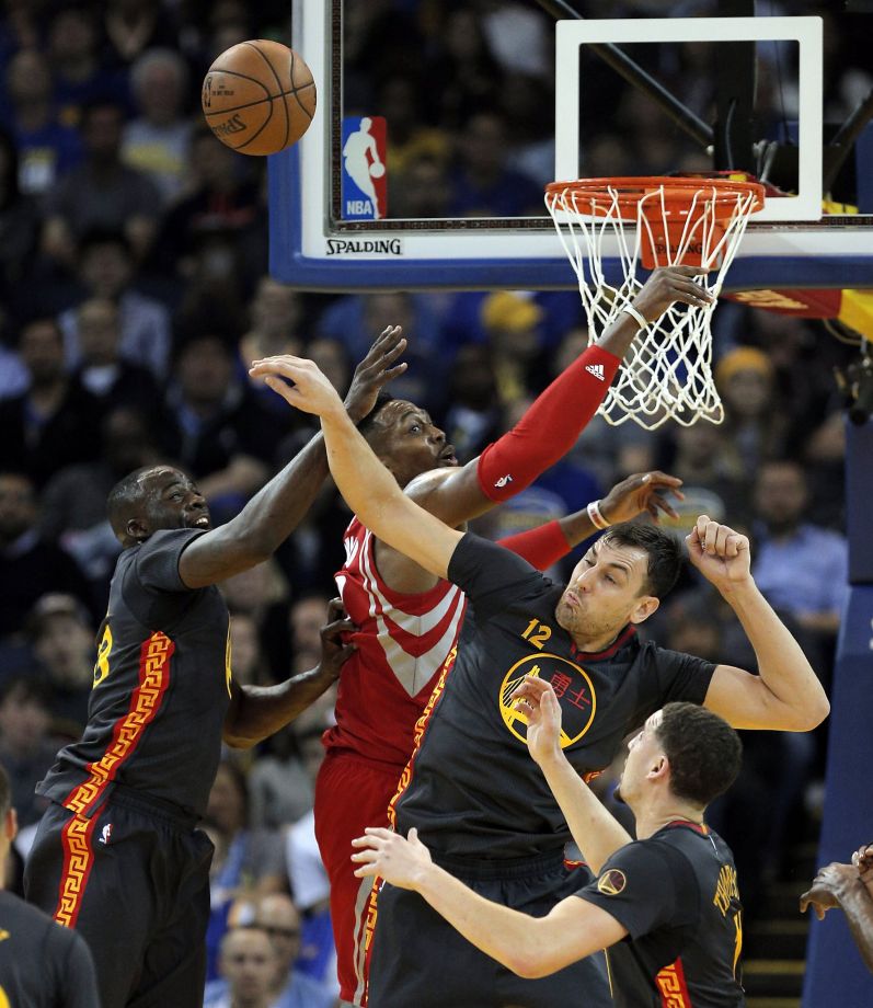 Draymond Green and Andrew Bogut battle against Dwight Howard for a rebound during the first half of the game between the Golden State Warriors and the Houston Rockets at Oracle Arena in Oakland Calif. on Tuesday