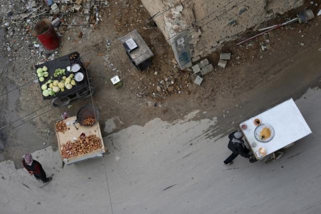 Men sell produce on their carts in the rebel held besieged city of Douma a suburb of Damascus Syria