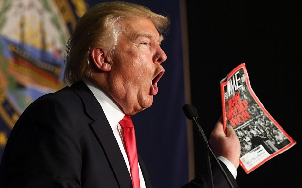 Presidential candidate Donald Trump shows off a Time magazine with a cover story titled