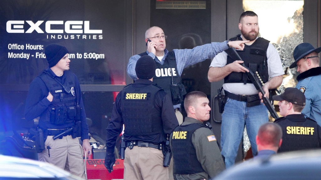 Police guard the front door of Excel Industries in Hesston Kan. where a gunman reportedly killed three people before being shot to death by a police officer