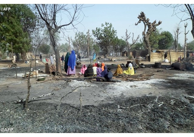 Women and children sit among burnt houses after Boko Haram attacks at Dalori village in northeastern Nigeria- AFP