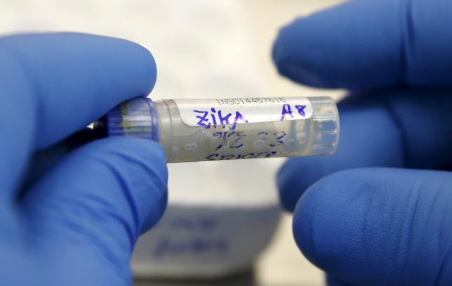 A health technician analyzes a blood sample from a patient bitten by a mosquito at the National Institute of Health in Lima Peru