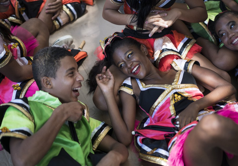 Young revelers joke with each other as they lay in the shade during a carnival event in Brazil. Scientists said Friday that they found the presence of Zika virus in saliva and urine samples which means the disease could be spread by more than just mosqui