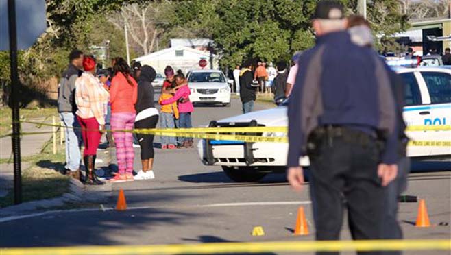 A woman embraces two children near the intersection of Davis Avenue and Ladnier Street in Pass Christian after a shooting on Sunday Feb. 7 2016. South Mississippi police say a shooting after a Mardi Gras parade in Pass Christian has left two people dead