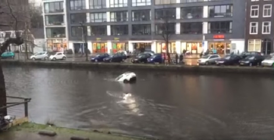 People dive into Amersterdam canal to save woman and child from sinking car - WATCH